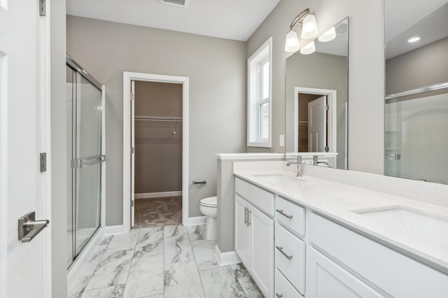 bathroom featuring a shower stall, a spacious closet, marble finish floor, and a sink