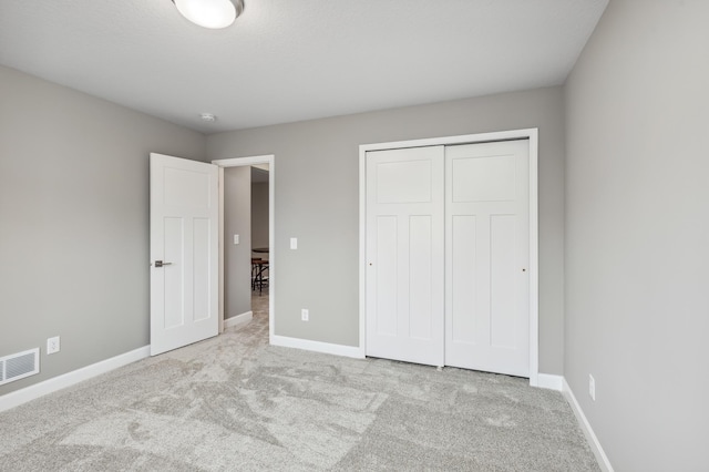 unfurnished bedroom with carpet flooring, baseboards, and visible vents