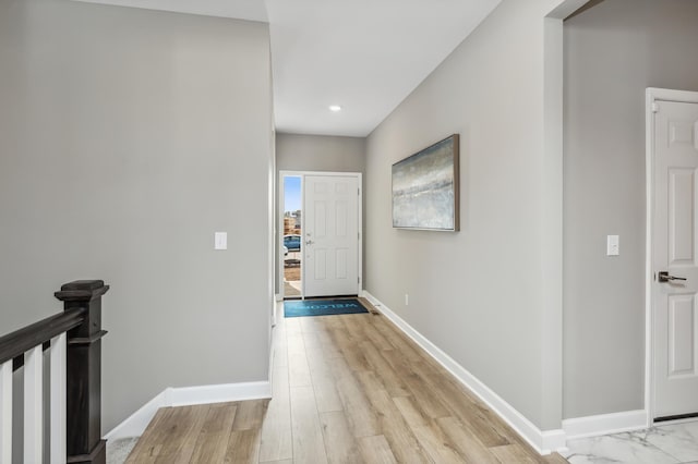 hallway featuring recessed lighting, light wood-style floors, and baseboards