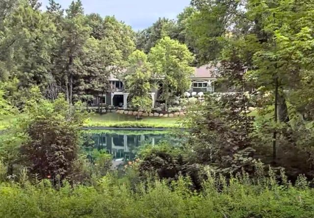 back of property featuring a wooded view