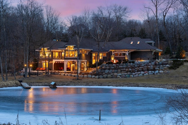 rear view of property featuring a forest view