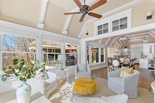 interior space with wine cooler, beam ceiling, ceiling fan with notable chandelier, wood finished floors, and high vaulted ceiling