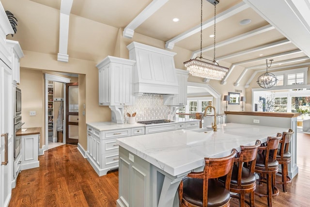 kitchen with backsplash, oven, dark wood-type flooring, premium range hood, and a sink