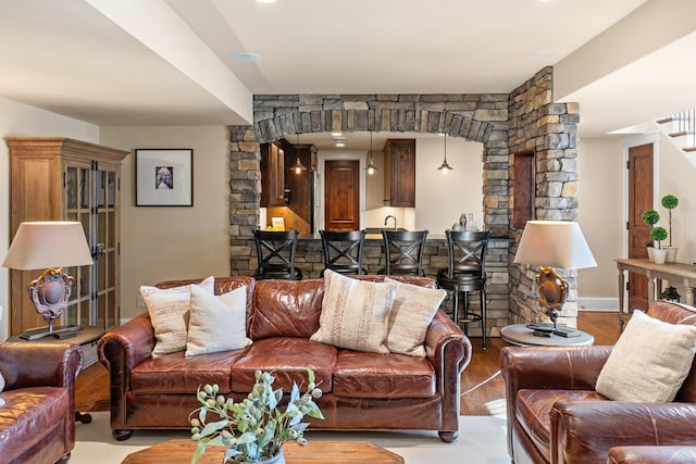 living room featuring wet bar, stairs, and wood finished floors