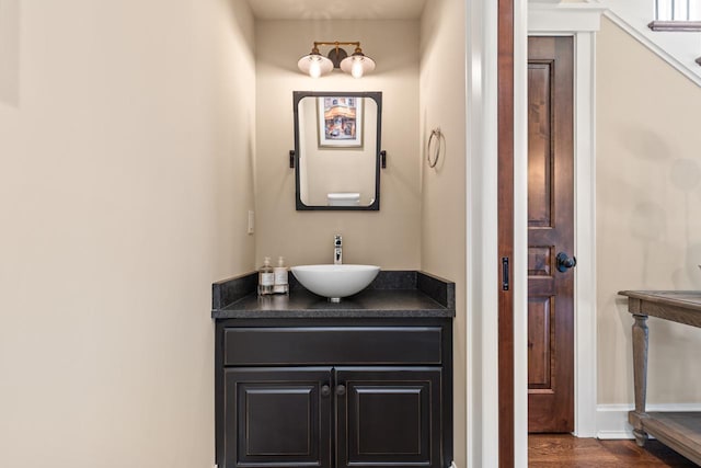 bathroom with vanity, wood finished floors, and baseboards