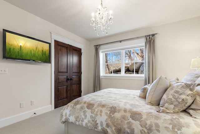 bedroom with a notable chandelier, carpet, and baseboards