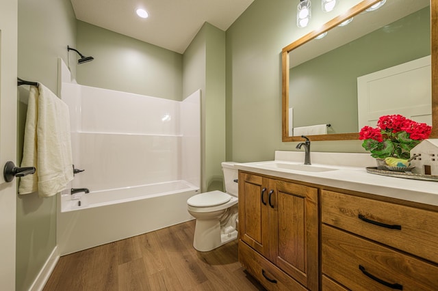 full bath with toilet, wood finished floors, vanity, and shower / tub combination