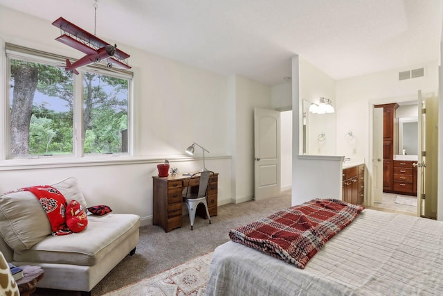 bedroom featuring baseboards, light colored carpet, visible vents, and connected bathroom