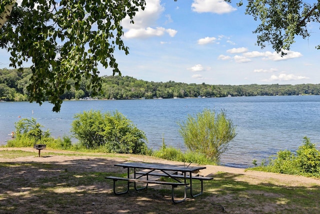 exterior space with a wooded view and a water view