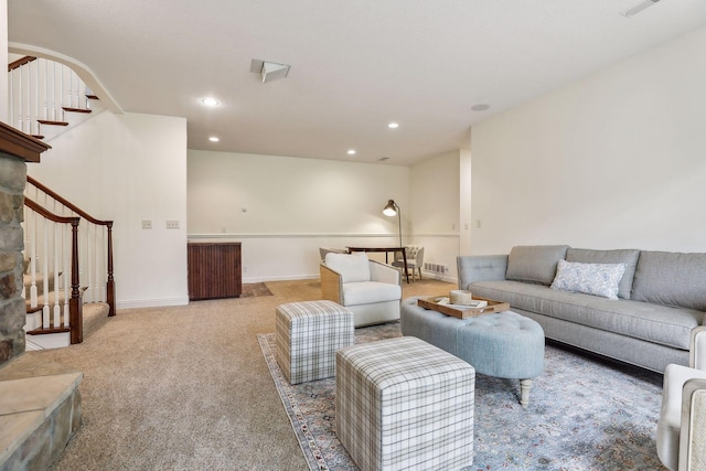 carpeted living area with arched walkways, stairway, recessed lighting, and baseboards