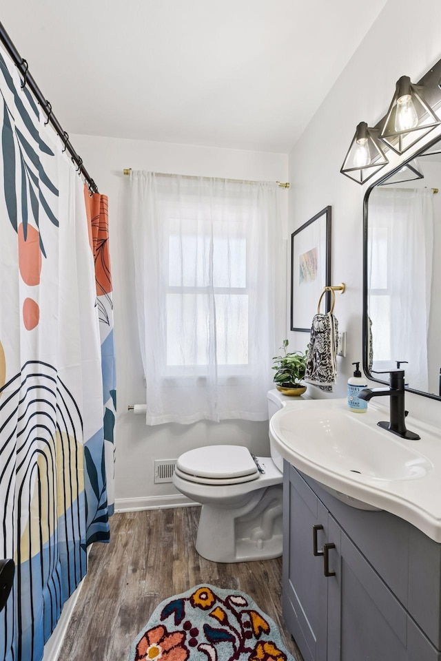 full bath featuring a shower with shower curtain, toilet, vanity, and wood finished floors