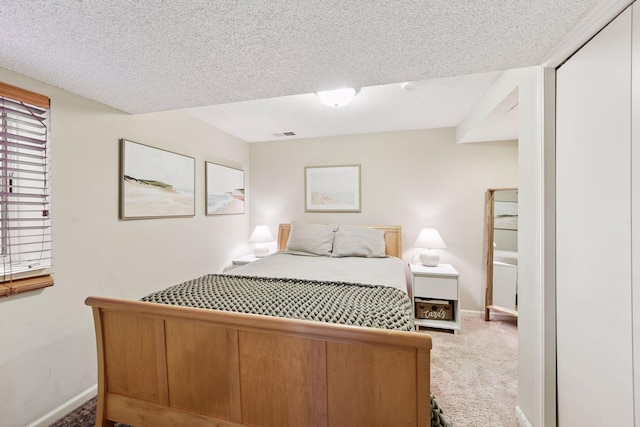 carpeted bedroom featuring visible vents, baseboards, and a textured ceiling