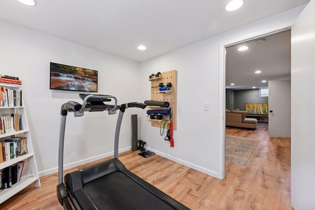 exercise room featuring recessed lighting, wood finished floors, and baseboards