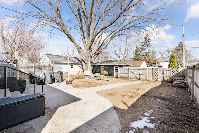 view of yard with an outdoor structure, a fenced backyard, and a patio area