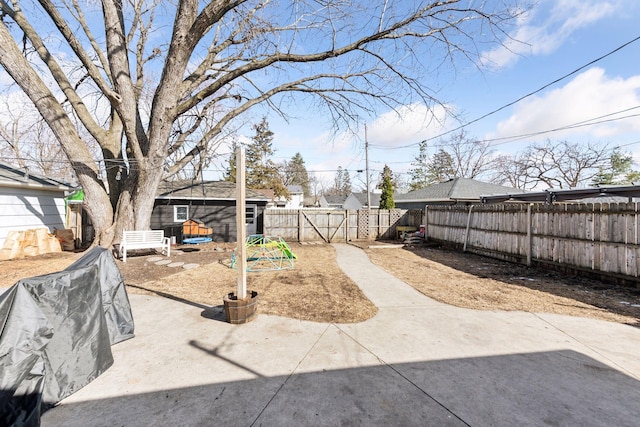 view of yard with a patio area, an outbuilding, and a fenced backyard