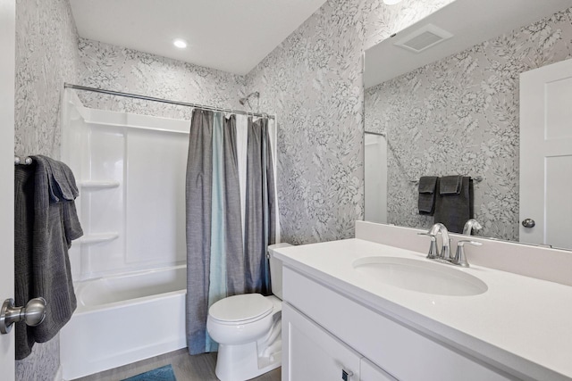 bathroom featuring shower / bath combo with shower curtain, toilet, vanity, and wallpapered walls