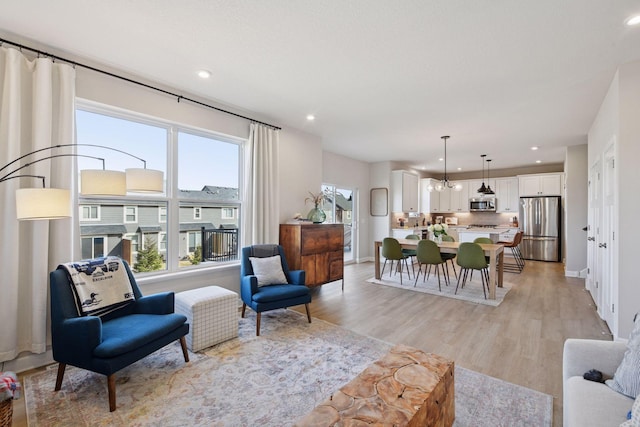 living area with recessed lighting, light wood-type flooring, and baseboards