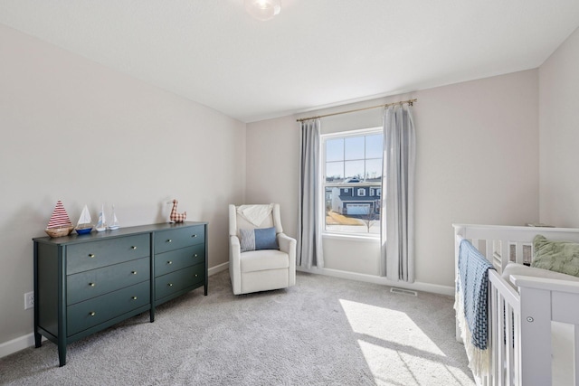 bedroom with baseboards, light carpet, a nursery area, and visible vents