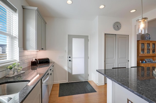 kitchen featuring dark stone counters, recessed lighting, decorative backsplash, light wood-style floors, and dishwasher