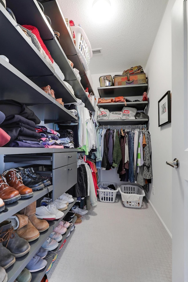 spacious closet featuring visible vents and carpet floors