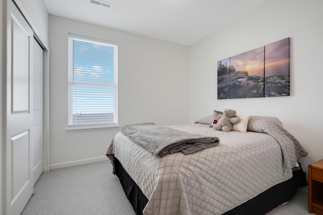 bedroom featuring carpet flooring, baseboards, visible vents, and a closet