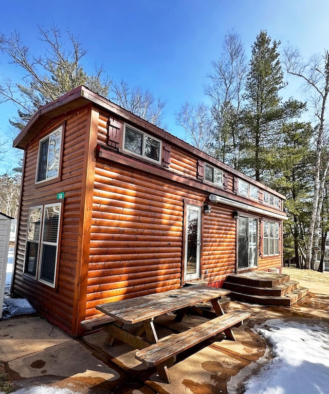 rear view of house featuring faux log siding