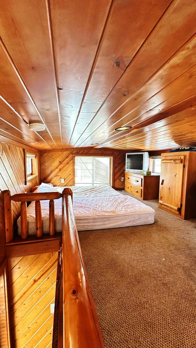 unfurnished bedroom with wood walls, wood ceiling, and carpet