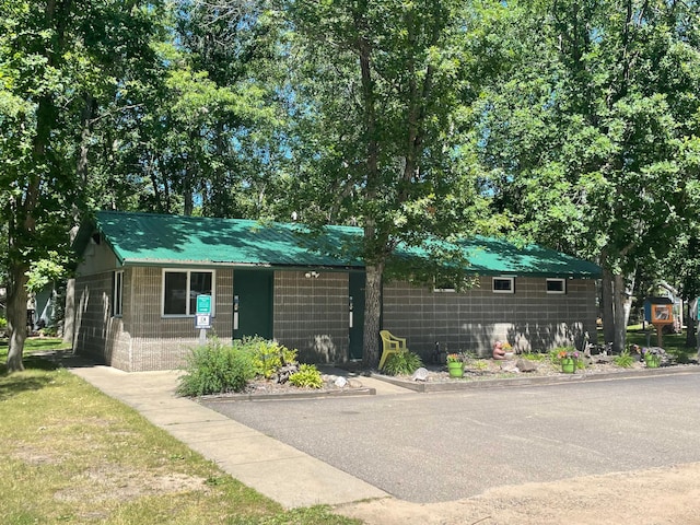 view of front of house with concrete block siding and metal roof