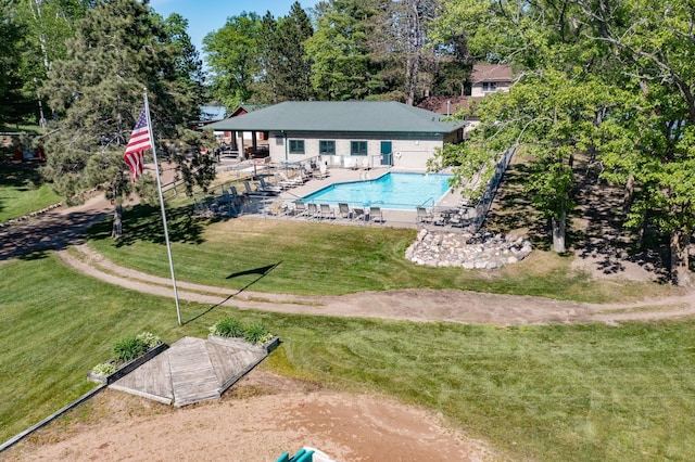 rear view of property with a yard, a patio, and a community pool