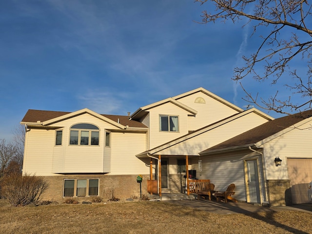 back of property with brick siding and covered porch