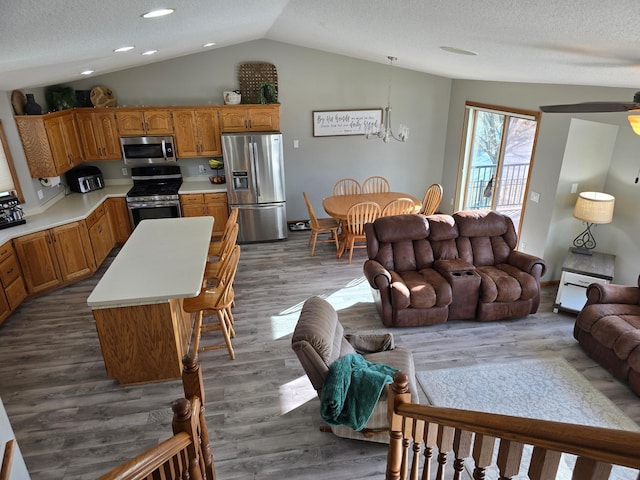 living area with lofted ceiling, a textured ceiling, a chandelier, and dark wood-style flooring