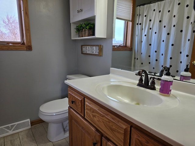 bathroom featuring visible vents, baseboards, toilet, a shower with shower curtain, and vanity