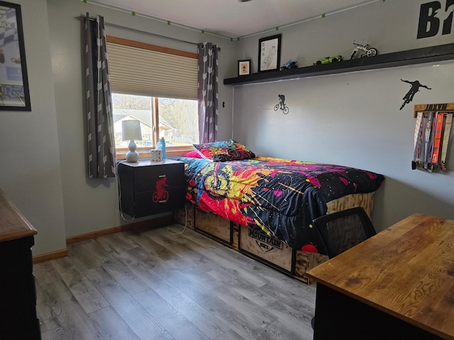 bedroom with baseboards and wood finished floors