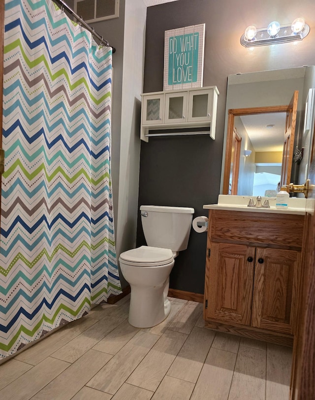 full bathroom featuring wood finish floors, visible vents, a shower with curtain, toilet, and vanity