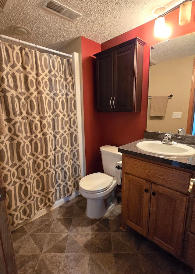 full bath featuring visible vents, toilet, vanity, a shower with shower curtain, and a textured ceiling