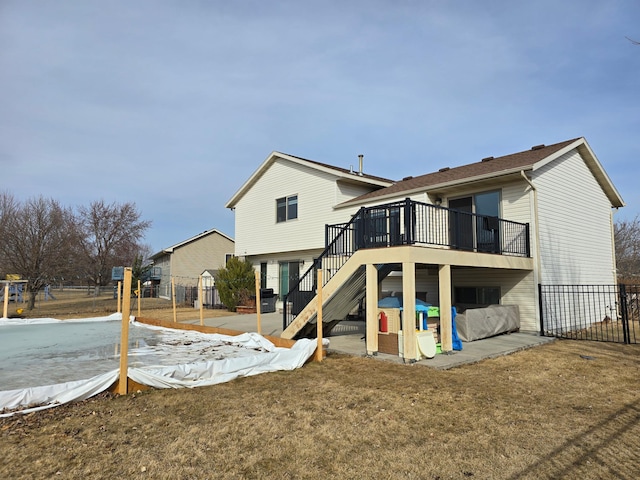 back of property with a wooden deck, stairs, and fence