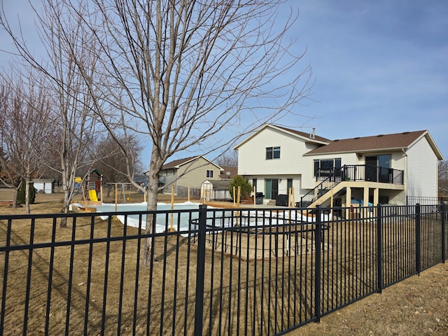 view of yard with a fenced in pool, a fenced backyard, stairs, and a playground