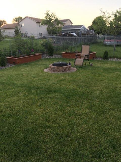 view of yard with a garden, an outdoor fire pit, and fence