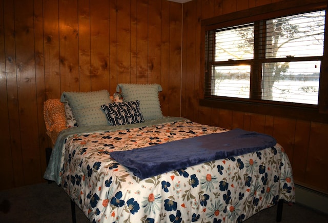 bedroom with baseboard heating and wood walls