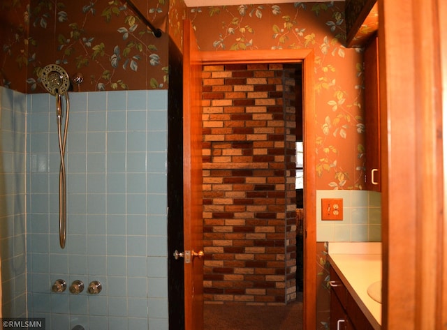 bathroom with wallpapered walls, vanity, and walk in shower