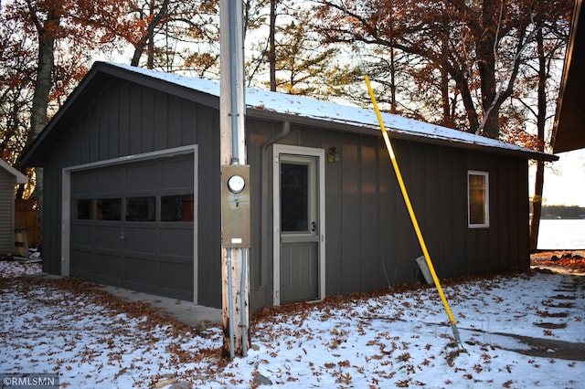 snow covered garage with a garage