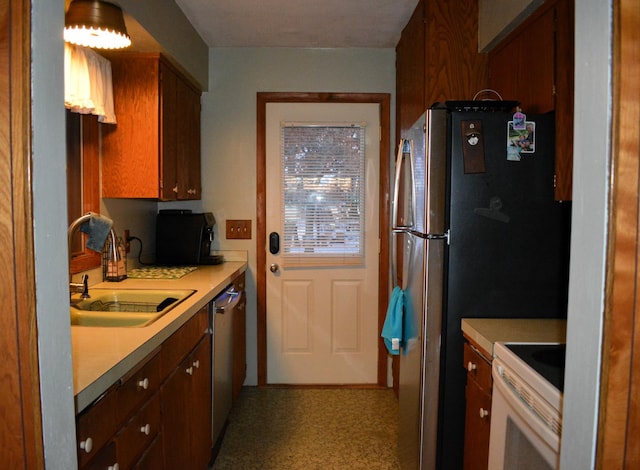 kitchen with stainless steel appliances, light countertops, and a sink