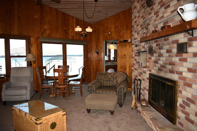 living room featuring a brick fireplace, wooden walls, carpet, and high vaulted ceiling