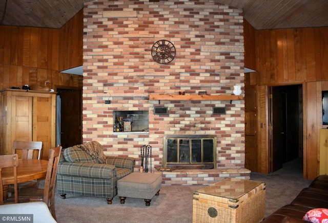 living area with carpet flooring, wood walls, a fireplace, and wooden ceiling