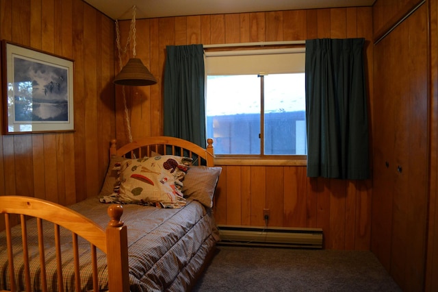 bedroom featuring baseboard heating, carpet flooring, and wooden walls