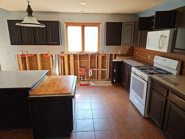 kitchen with tile patterned flooring, pendant lighting, white appliances, and tasteful backsplash