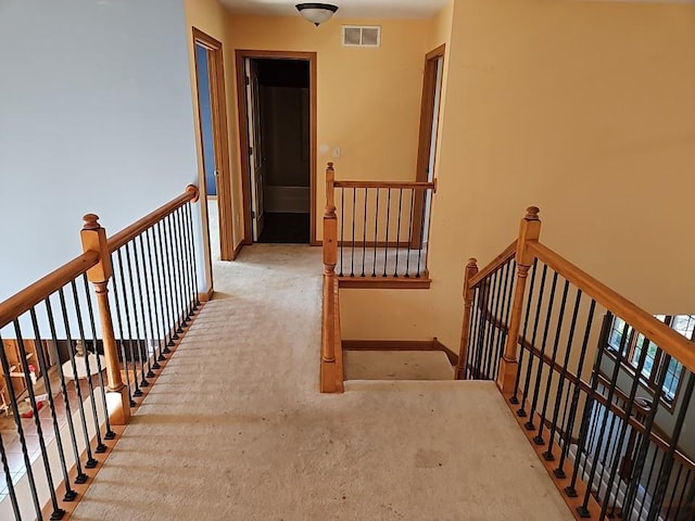 stairway with visible vents, carpet flooring, and baseboards