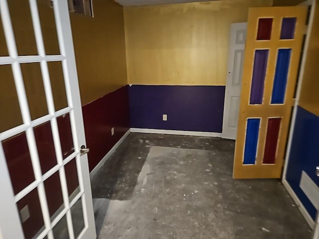 unfurnished room with baseboards and concrete floors