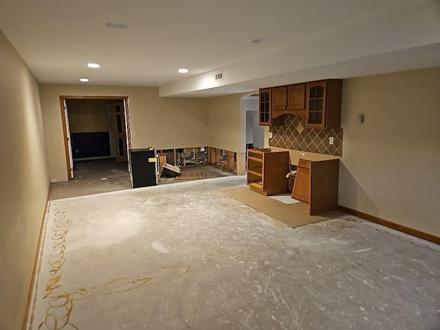 kitchen with visible vents, baseboards, recessed lighting, glass insert cabinets, and brown cabinets