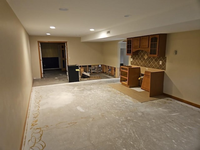 kitchen featuring brown cabinetry, baseboards, recessed lighting, glass insert cabinets, and tasteful backsplash